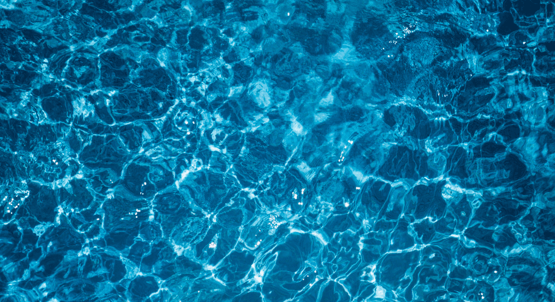 Clear blue water with sunlight reflecting on the rippled surface, creating bright, wavy patterns.